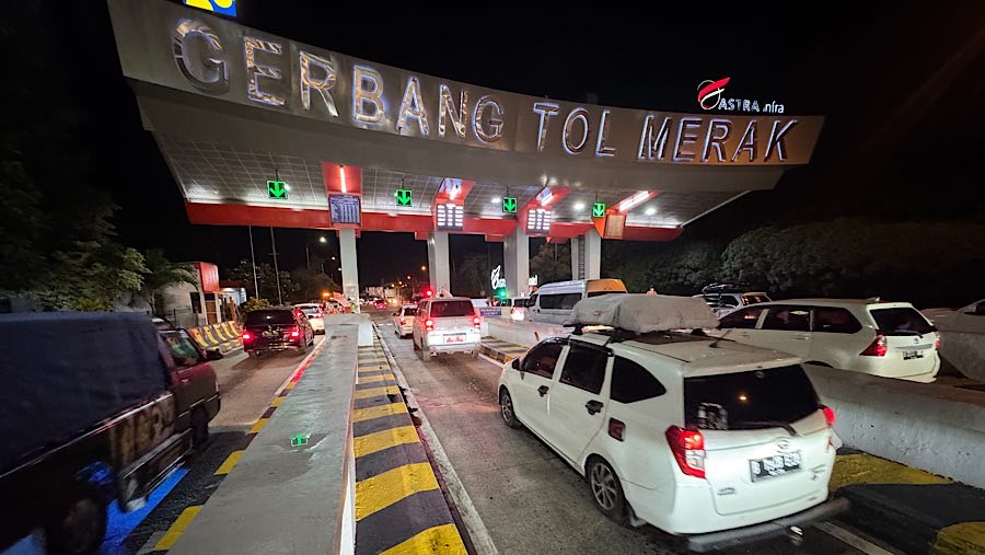 Sejumlah mobil pemudik antre untuk keluar dari gerbang tol Merak di Cilegon, Banten, Jumat (28/3/2025). (Bloomberg Technoz/Andrean Kristianto)