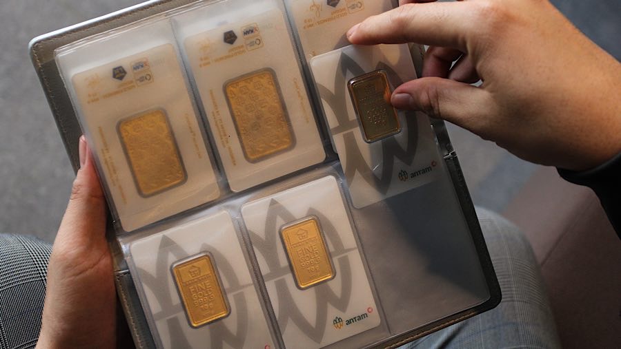 Karyawan meletakkan Logam Mulia kedalam dompet di Butik Emas Antam, Pulogadung, Kamis (10/4/2025). (Bloomberg Technoz/Andrean Kristianto)