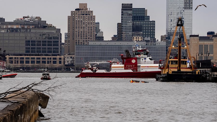 Puing-puing mengapung saat petugas di lokasi jatuhnya helikopter di Sungai Hudson, New Jersey, AS, Kamis (10/4/2025). (David Dee Delgado/Bloomberg)