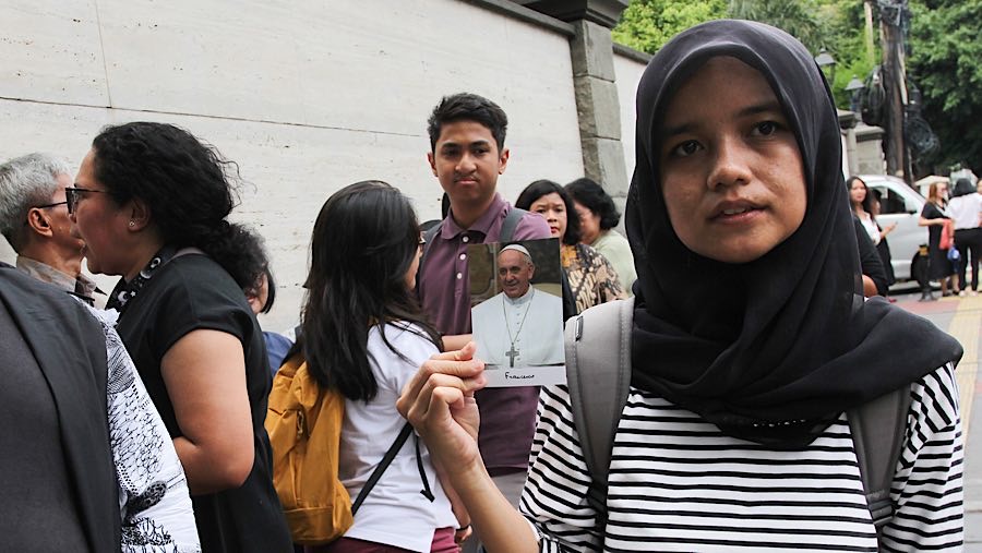 Mereka mengantre untuk diberikan kesempatan berdoa di dalam Kedubes. (Bloomberg Technoz/Andrean Kristianto)