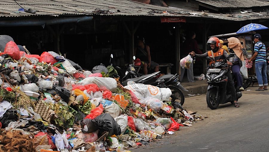 Warga membuang sampah di jalan raya Cimanggis, Ciputat, Tangsel, Rabu (23/4/2025). (Bloomberg Technoz/Andrean Kristianto)