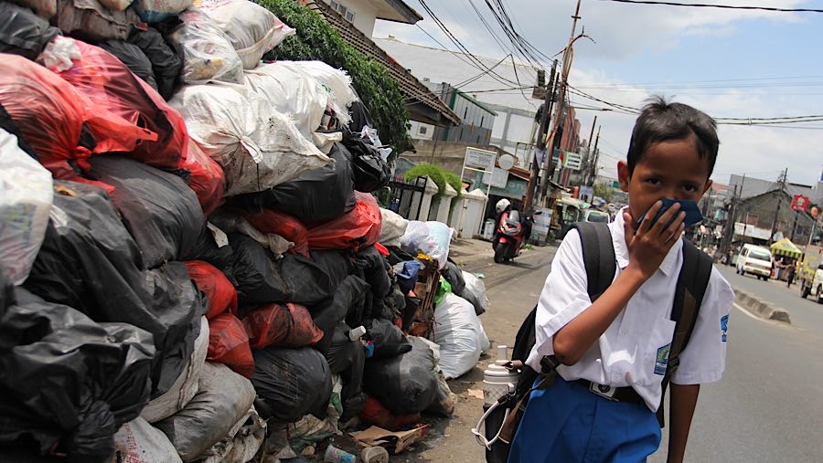 Beberapa pejalan kaki harus menutup hidung karena bau yang tidak sedap dari sampah tersebut. (Bloomberg Technoz/Andrean Kristianto)
