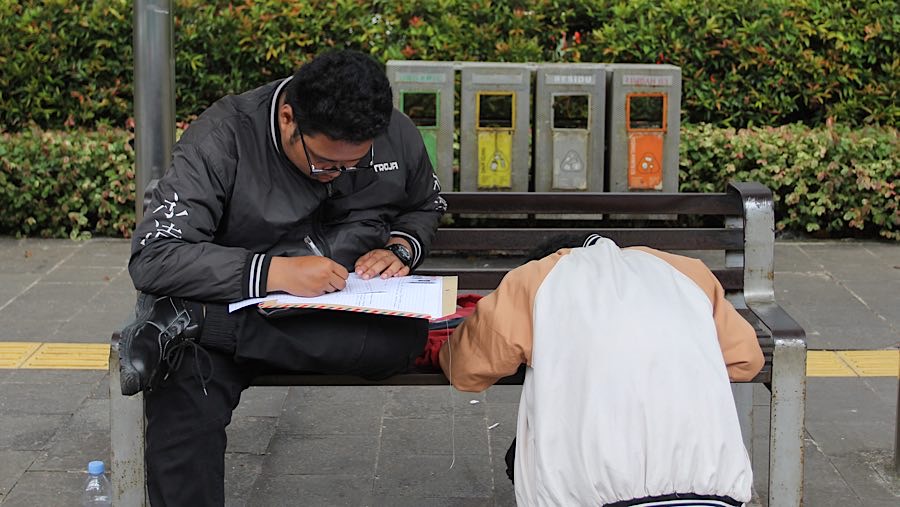 Beberapa pelamar terlihat sibuk menyiapkan berkas yang akan digunakan untuk melamar. (Bloomberg Technoz/Andrean Kristianto)