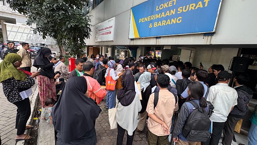 Para pelamar tampak mengantre di loket penerimaan surat dan barang dengan membawa amplop coklat l. (Bloomberg Technoz/Andrean Kristianto)