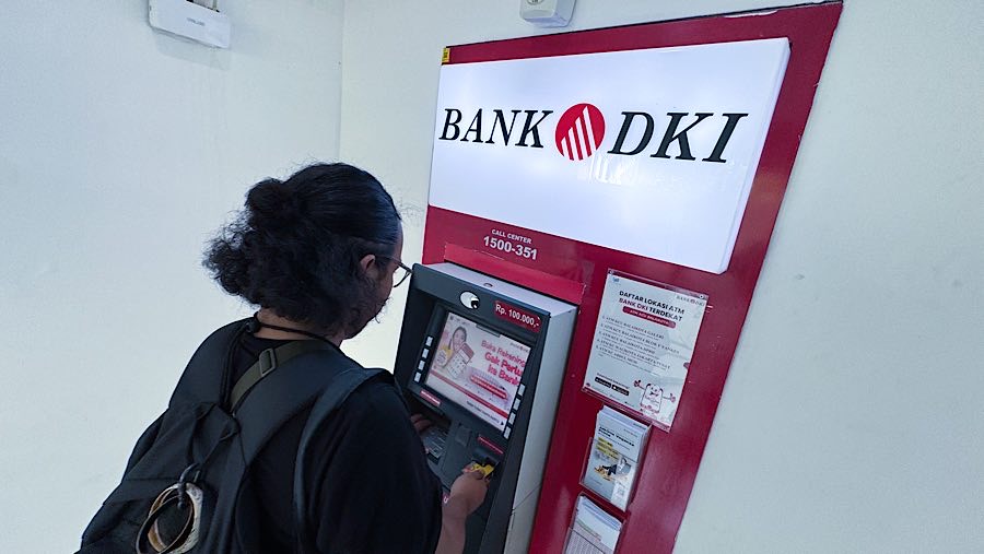 Nasabah bertransaksi di mesin ATM Bank DKI di Jakarta, Rabu (23/4/2025). (Bloomberg Technoz/Andrean Kristianto)