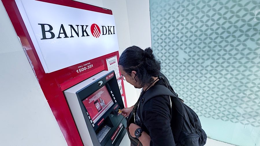 Nasabah bertransaksi di mesin ATM Bank DKI di Jakarta, Rabu (23/4/2025). (Bloomberg Technoz/Andrean Kristianto)