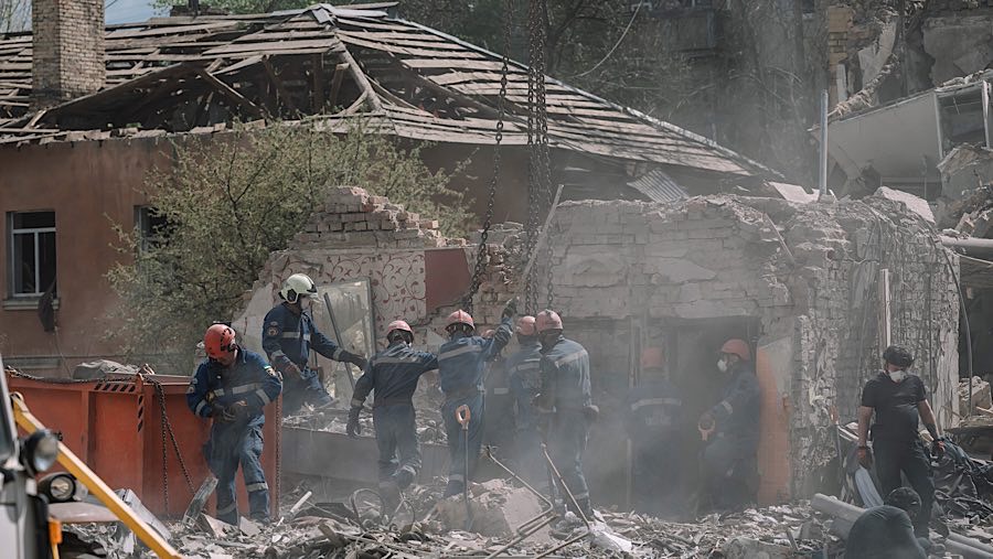 Petugas penyelamat berada diatas puing-puing bangunan setelah serangan rudal Rusia di Kyiv, Ukraina, Kamis (24/5/2025). (Andrew Kravchenko/Bloomberg)