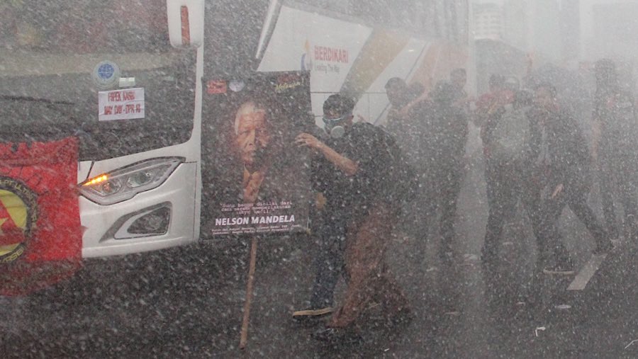 Polisi menyemprotkan air menggunakan water cannon untuk memukul mundur massa. (Bloomberg Technoz/Andrean Kristianto)