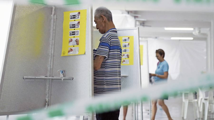 Seorang pemilih mengisi surat suara di tempat pemungutan suara di Singapura pada tanggal 3 Mei. (Fotografer: Ore Huiying/Bloomberg)