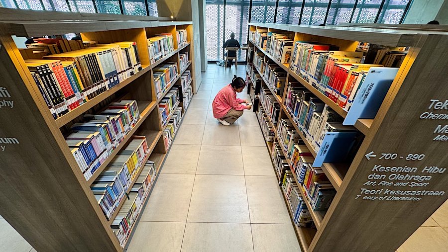 Pengunjung memilih buku di Perpustakaan Jakarta, Taman Ismail Marzuki, Selasa (6/5/2025). (Bloomberg Technoz/Andrean Kristianto)