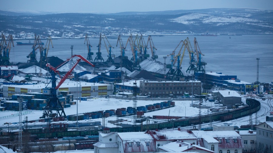 Gerbong batu bara yang tertutup salju dan derek industri terlihat di pelabuhan Murmansk, Rusia./Bloomberg-Andrey Rudakov