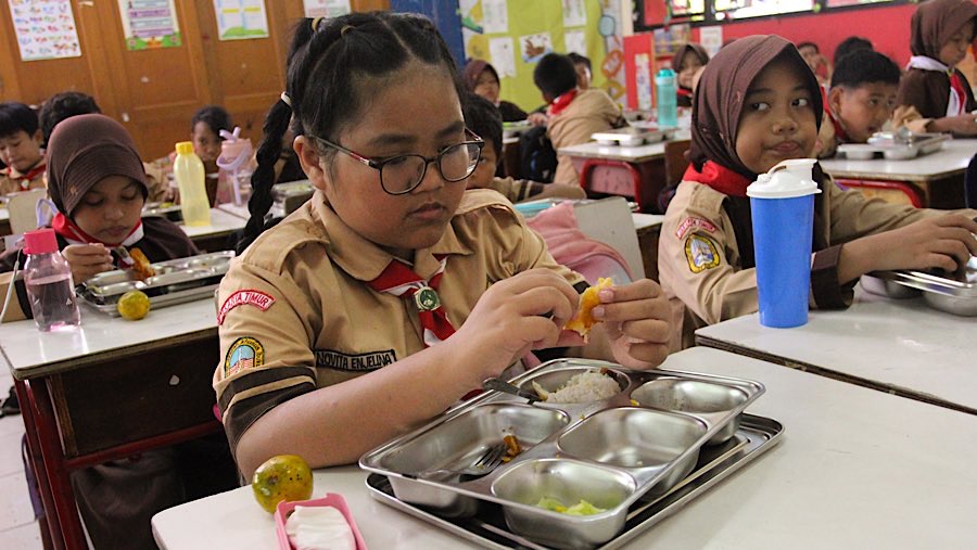 Siswa menyantap Makan Bergizi Gratis di SDN Jati 03 Pulo Asem, Jakarta, Rabu (7/5/2025). (Bloomberg Technoz/Andrean Kristianto)
