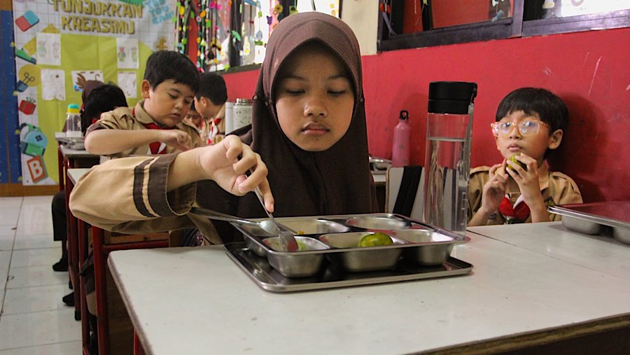 Siswa menyantap Makan Bergizi Gratis di SDN Jati 03 Pulo Asem, Jakarta, Rabu (7/5/2025). (Bloomberg Technoz/Andrean Kristianto)