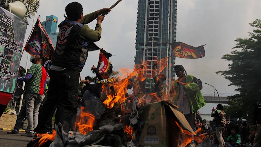 Massa aksi juga sempat membakar kardus sambil bersorak menyampaikan tuntutan mereka. (Bloomberg Technoz/Andrean Kristianto)