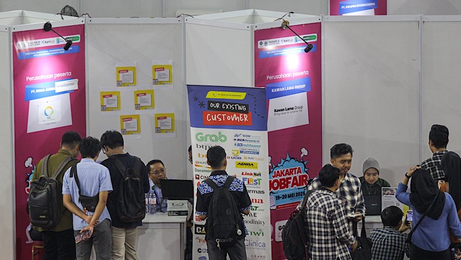 Pencari kerja memadati stan perusahaan pada Bursa Kerja Jakarta di GOR Ciracas, Senin (19/5/2025). (Bloomberg Technoz/Andrean Kristianto)