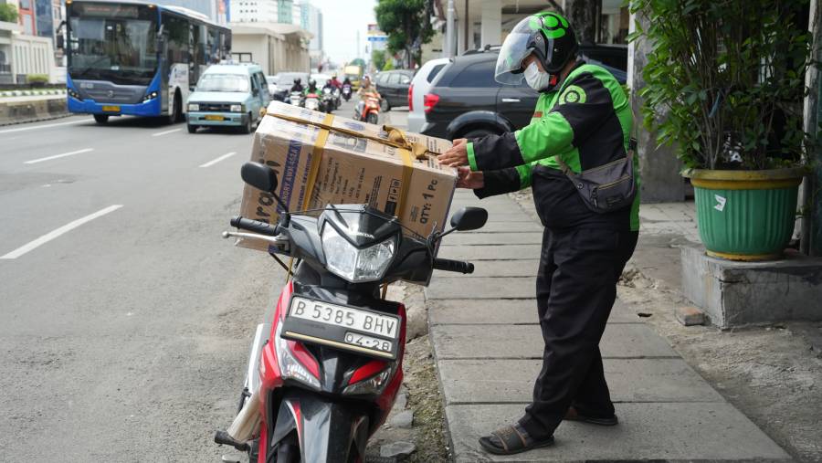 Mitra ojol Gojek mengantarkan paket ke pelanggan. (Bloomberg)