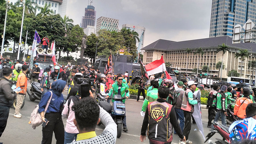 Ratusan Massa Ojol mulai bergerak ke Patung Kuda (Ibnu Affan/Bloomberg Technoz)