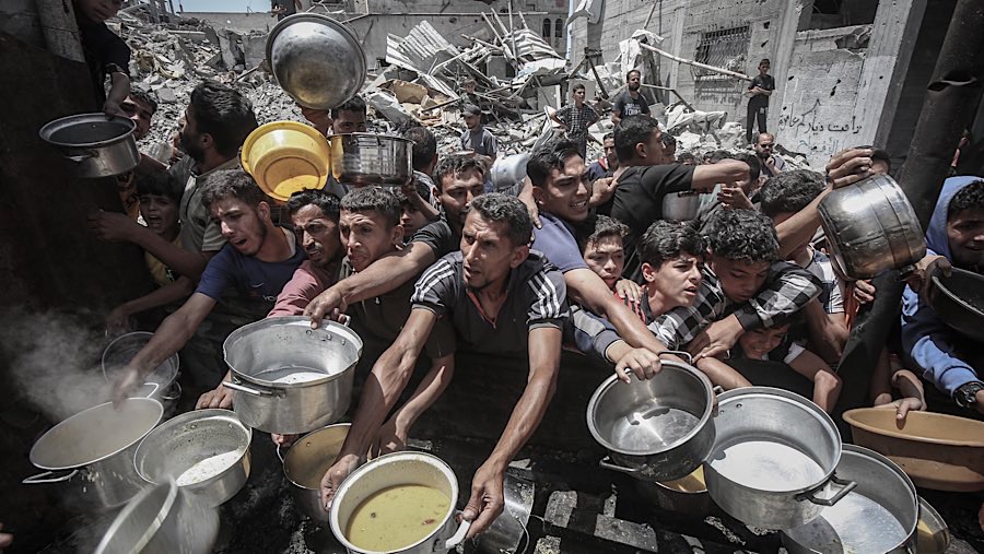 Warga Palestina mengulurkan tangan untuk mendapatkan makanan dari dapur umum di Jabaliya, Gaza utara, Senin (19/5/202). (Ahmad Salem/Bloomberg)