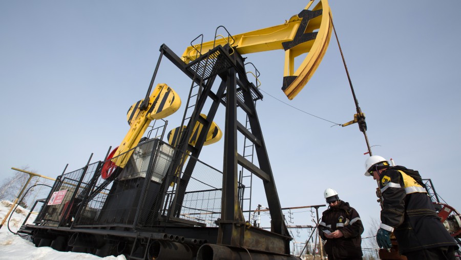 Pekerja memeriksa dongkrak pemompaan minyakdi lokasi pemompaan, yang dioperasikan oleh Rosneft PJSC di Rusia./Bloomberg-Andrey Rudakov