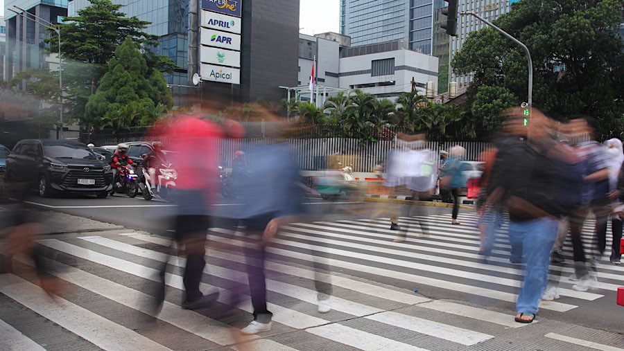 Pekerja berjalan di kawasan Sudirman, Jakarta, Senin (26/5/2025). (Bloomberg Technoz/Andrean Kristianto)