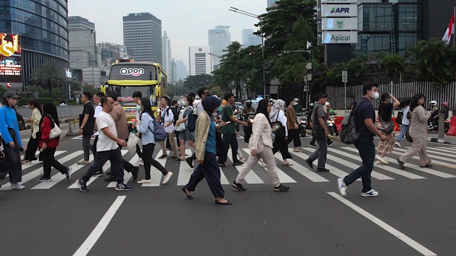 Pekerja berjalan di kawasan Sudirman, Jakarta, Senin (26/5/2025). (Bloomberg Technoz/Andrean Kristianto)