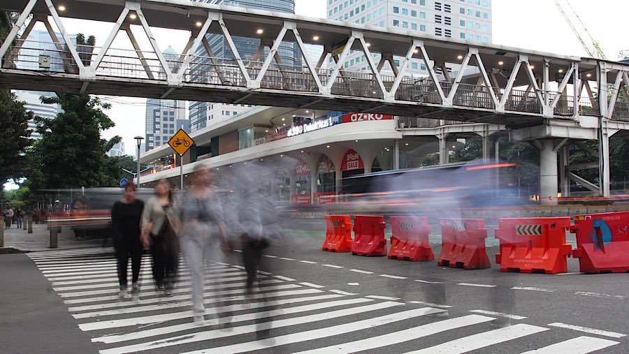 Pekerja berjalan di kawasan Sudirman, Jakarta, Senin (26/5/2025). (Bloomberg Technoz/Andrean Kristianto)