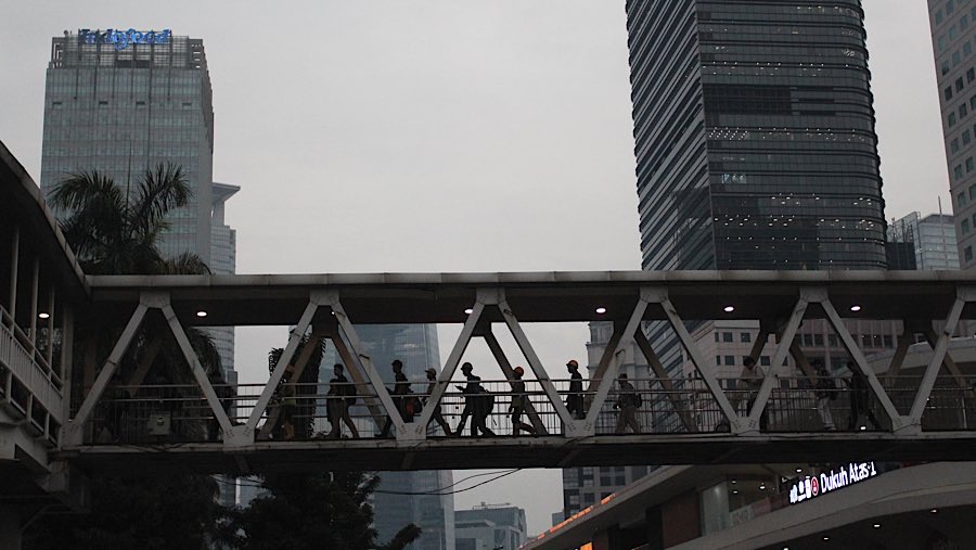 Pekerja berjalan di kawasan Sudirman, Jakarta, Senin (26/5/2025). (Bloomberg Technoz/Andrean Kristianto)