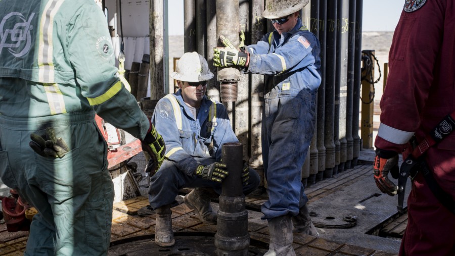 Operator rig minyak Precision Drilling memasang pemandu bit di lantai rig minyak Royal Dutch Shell Plc./Bloomberg-Matthew Busch