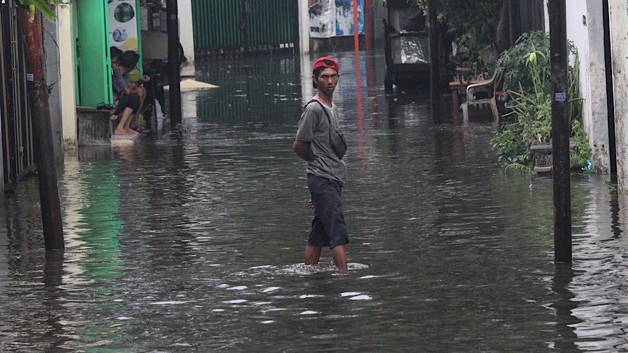 Warga berjalan melewati banjir di Jalan Bangka 1, Jakarta, Selasa (3/6/2025). (Bloomberg Technoz/Andrean Kristianto)