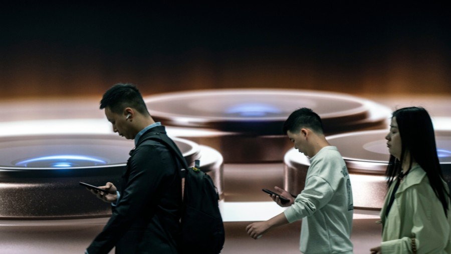 Ilustrasi pengguna iPhone melintas di subway Shanghai, China. (Qilai Shen/Bloomberg)