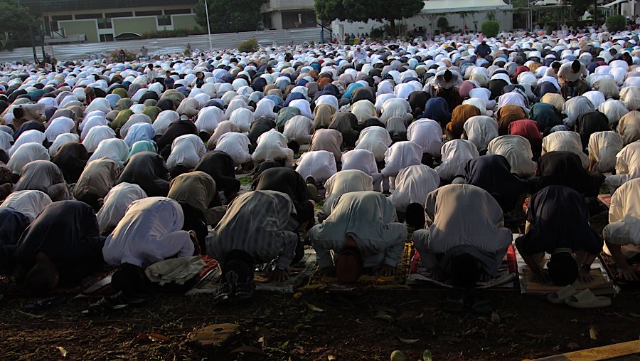 Umat Islam hadir membawa perlengkapan salat seperti sajadah dan tikar. (Bloomberg Technoz/Andrean Kristianto)