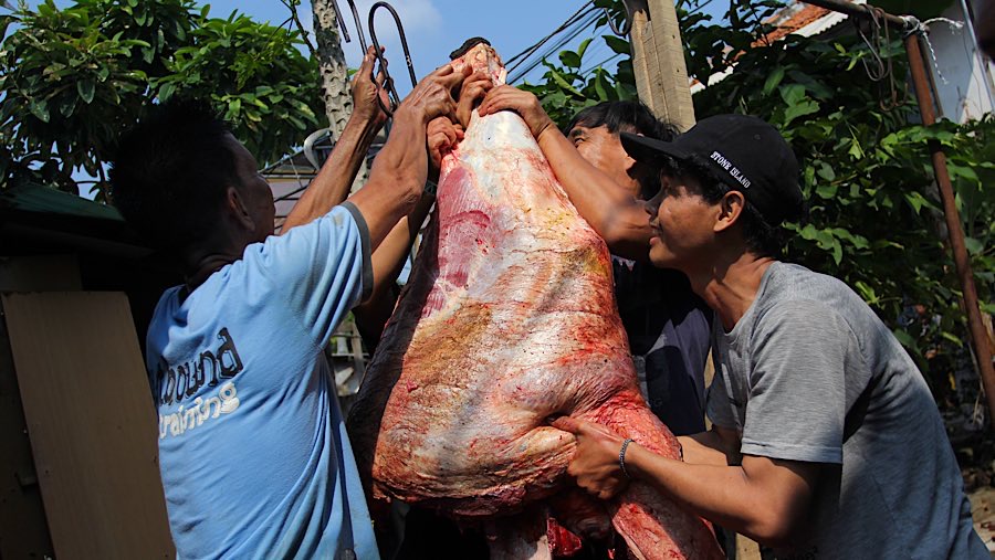 Warga menggantung daging kurban di kawasan Kebon Melati, Jakarta, Jumat (6/6/2025). (Bloomberg Technoz/Andrean Kristianto)