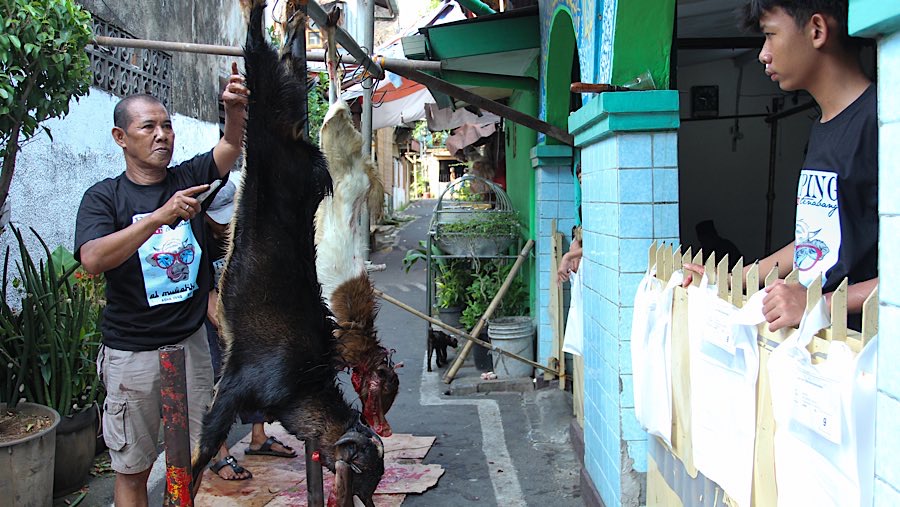 Warga memotong daging kurban di kawasan Kebon Melati, Jakarta, Jumat (6/6/2025). (Bloomberg Technoz/Andrean Kristianto)