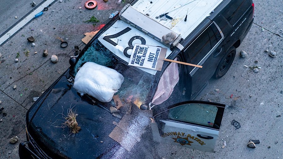 Bentrokan meningkat pada hari Minggu (8/6/2025), beberapa orang melakukan vandalisme dan kekerasan, termasuk membakar mobil. (Kyle Grillot/Bloomberg)