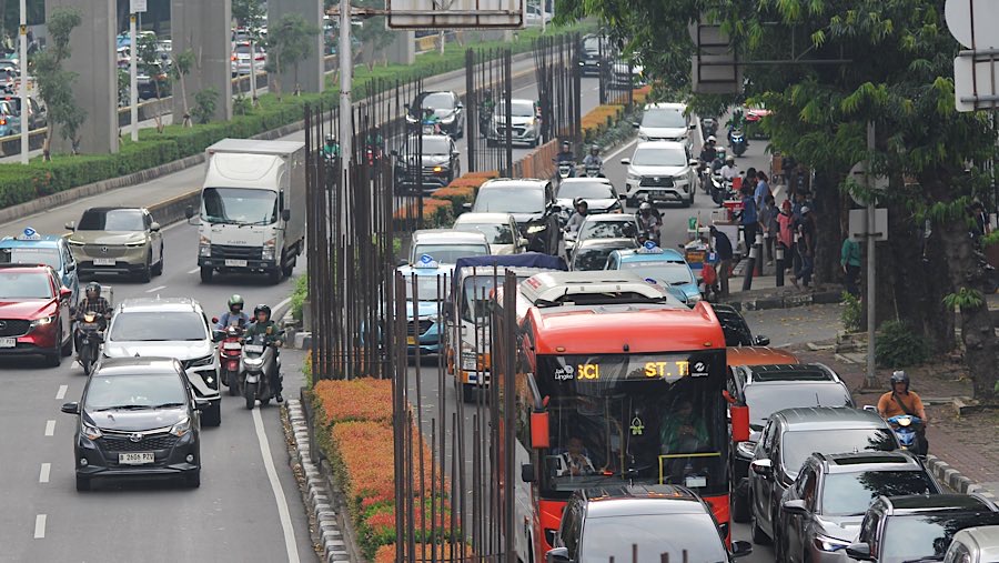 Pengendara melintas di dekat tiang proyek monorel Jakarta di kawasan Jalan HR Rasuna Said, Rabu (11/6/2025). (Bloomberg Technoz/Andrean Kristianto)