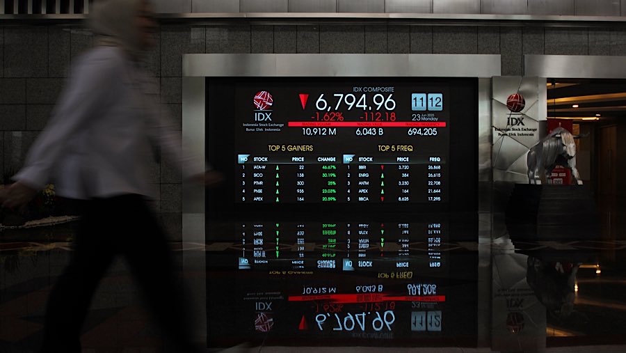 Karyawan di depan layar indeks harga saham gabungan (IHSG) di Bursa Efek Indonesia (BEI), Senin (23/62025). (Bloomberg Technoz/Andrean Kristianto)