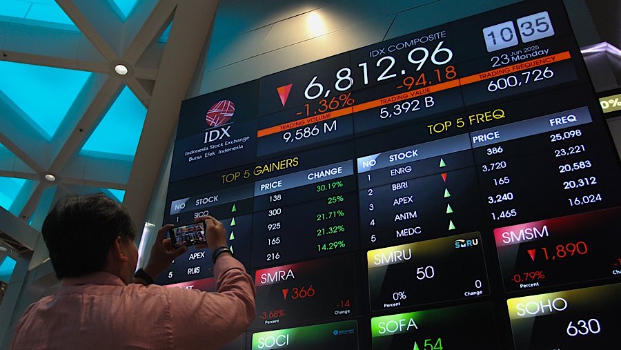 Karyawan di depan layar indeks harga saham gabungan (IHSG) di Bursa Efek Indonesia (BEI), Senin (23/62025). (Bloomberg Technoz/Andrean Kristianto)
