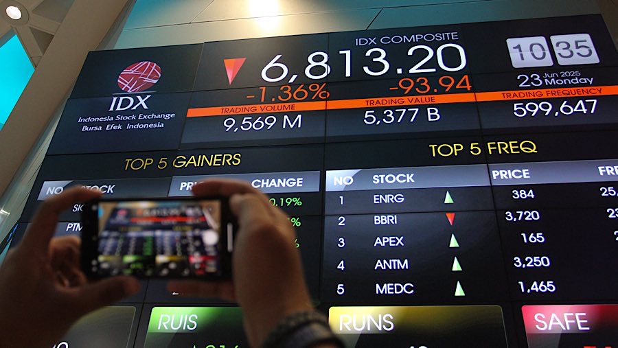 Karyawan memfoto layar indeks harga saham gabungan (IHSG) di Bursa Efek Indonesia (BEI), Senin (23/62025). (Bloomberg Technoz/Andrean Kristianto)
