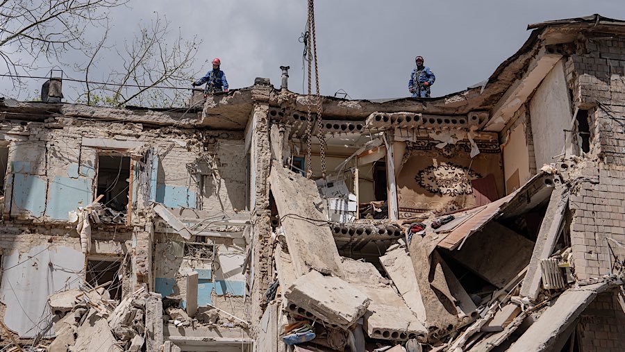 Petugas menyisir lokasi serangan udara Rusia terhadap bangunan tempat tinggal di Kyiv, Ukraina, Senin (23/6/2025). (Andrew Kravchenko/Bloomberg)
