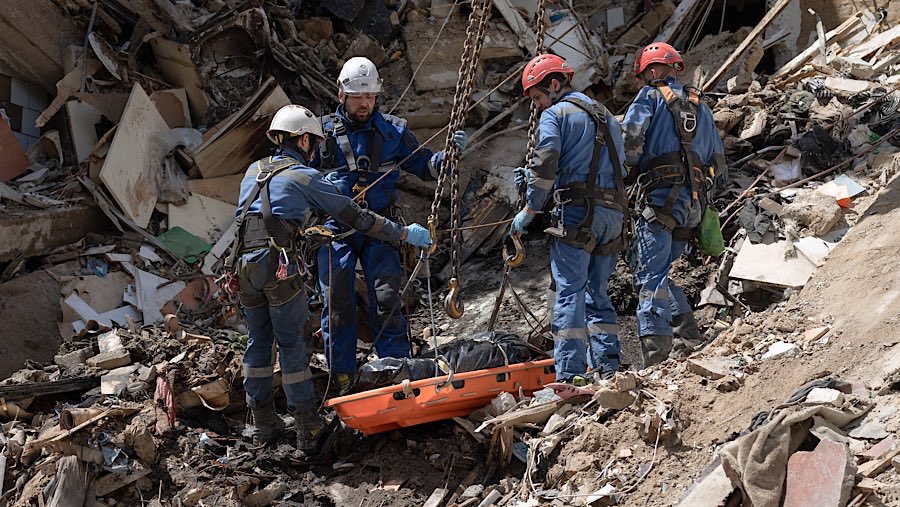 Petugas memindahkan jenazah dari bangunan setelah serangan udara Rusia di Kyiv, Ukraina, Senin (23/6/2025). (Andrew Kravchenko/Bloomberg)