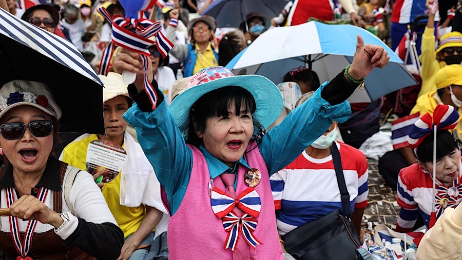 Mereka membawa bendera, sementara sejumlah biksu memimpin doa dan nyanyian di atas panggung.  (Valeria Mongelli/Bloomberg)
