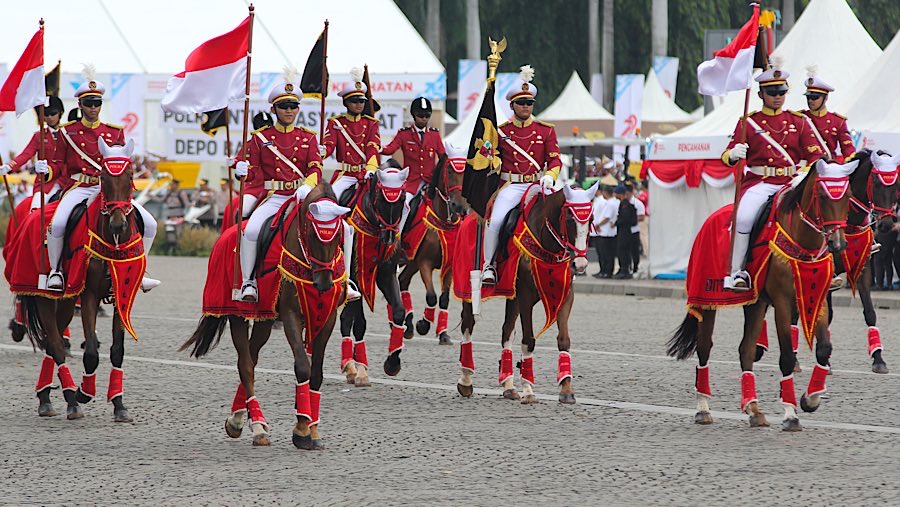 Pasukan berkuda tampil dalam acara HUT ke-79 Bhayangkara di Monas, Selasa (1/7/2025). (Bloomberg Technoz/Andrean Kristianto)