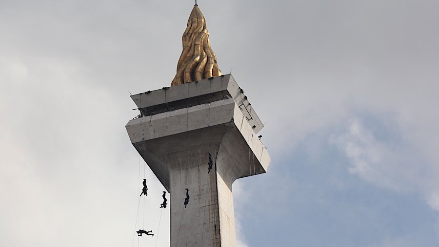 Tim Gegana melakukan teknik rippling freefall dalam acara HUT ke-79 Bhayangkara di Monas, Selasa (1/7/2025). (Bloomberg Technoz/Andrean Kristianto)