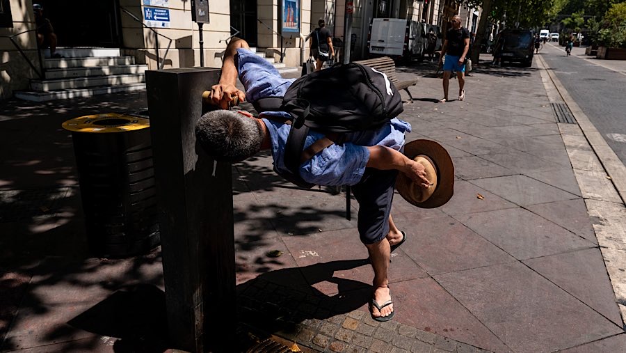 Pejalan kaki minum dari pancuran air saat gelombang panas melanda Marseille, Prancis, Selasa (1/7/2025). (Jeremy Suyker/Bloomberg)