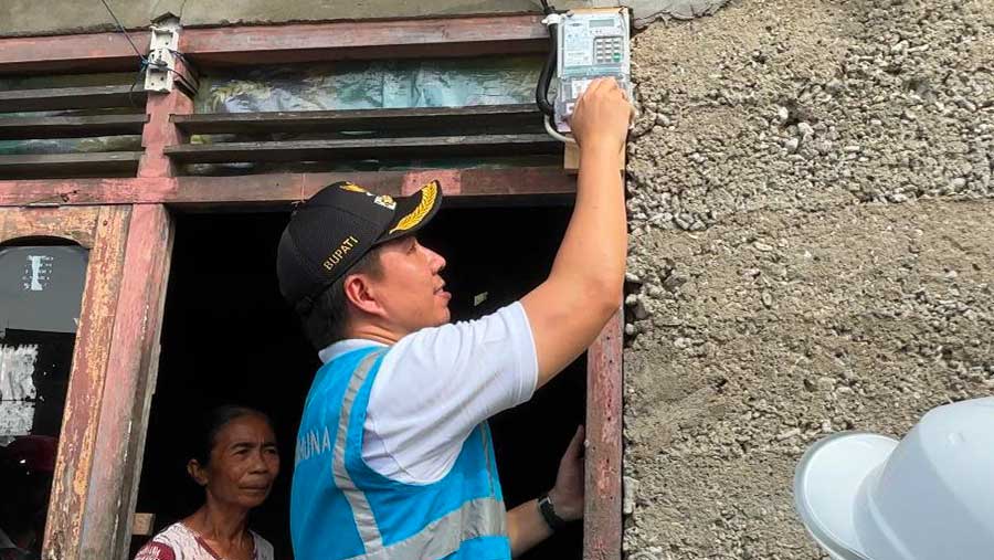 Bupati Kepulauan Sangihe, Michael Thungari (kanan) secara simbolis menyalakan listrik di rumah Nur Mandak (kiri), salah satu warga Pulau Lipang (PLN)