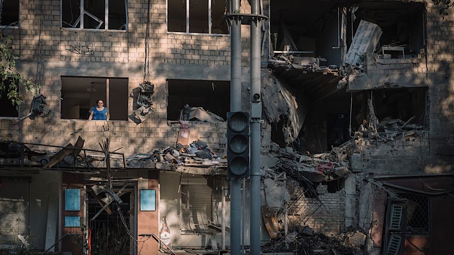 Warga melihat keluar dari apartemen yang rusak setelah serangan udara Rusia di Kyiv, Ukraina, Jumat (4/7/2025). (Andrew Kravchenko/Bloomberg)