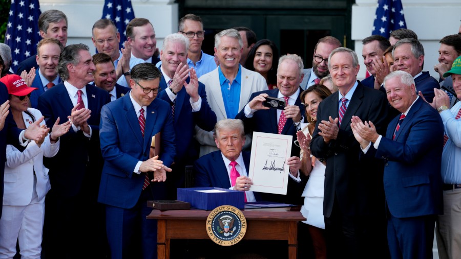 Trump menunjukkan RUU yang telah ditandatangani di Gedung Putih. (Fotografer: Kent Nishimura/Bloomberg)