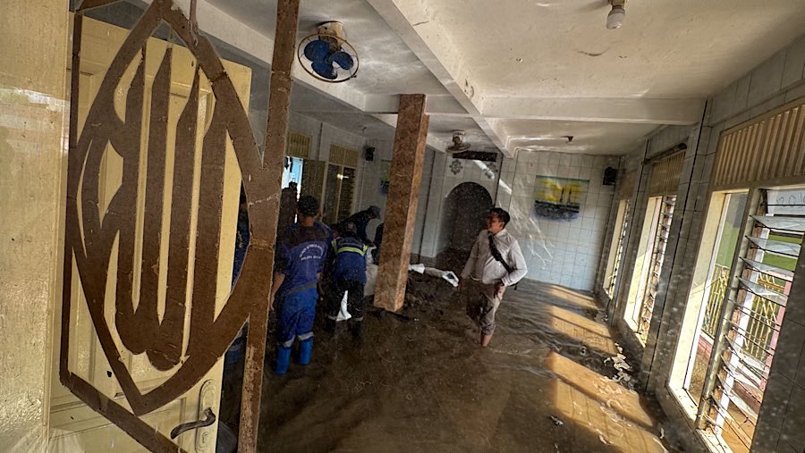 Petugas membersihkan musala yang terendam banjir di kawasan Kelurahan Jati Padang, Jakarta, Senin (7/7/2025).(Bloomberg Technoz/Andrean Kristianto)
