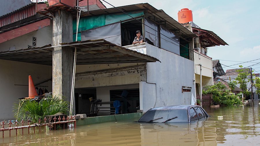 Meski banjir terlihat beberapa warga tetap bertahan di dalam rumahnya yang memiliki lantai 2. (Bloomberg Technoz/Andrean Kristianto)
