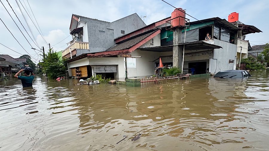 Warga bertahan di rumahnya saat banjir melanda Perumahan Ciledug Indah I, Tangerang, Banten, Selasa (8/7/2025). (Bloomberg Technoz/Andrean Kristianto)